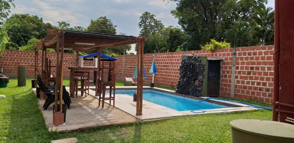 einen Pool mit einem Pavillon neben einer Ziegelwand in der Unterkunft La Chiqui - Quinta - Alquiler Temporario in Formosa