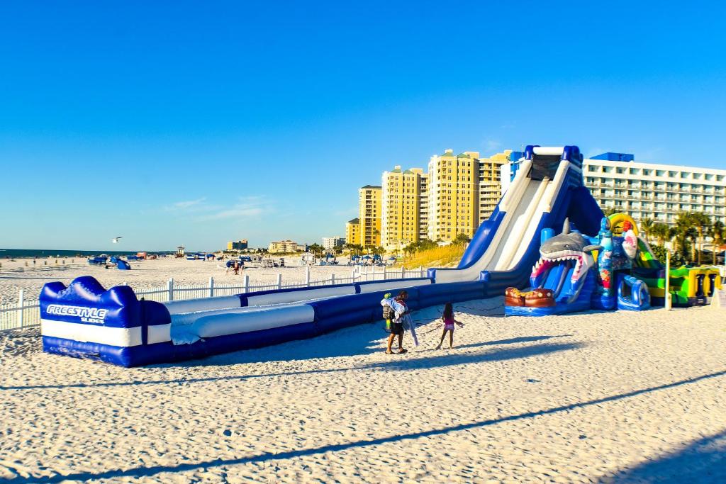 a group of people on a beach with a slide at Devon Shores in Clearwater Beach