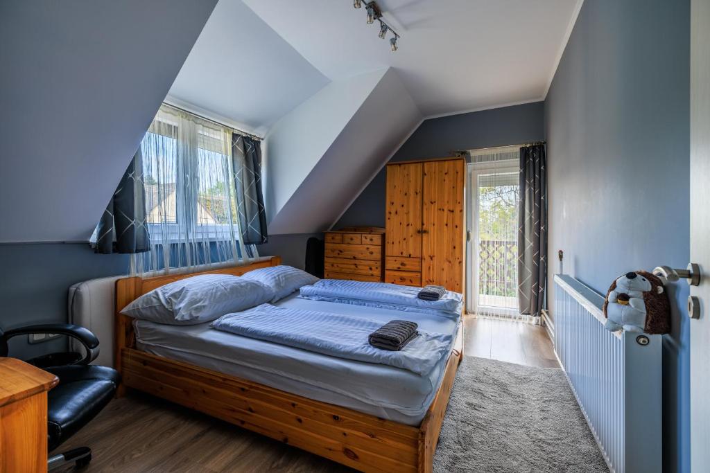 um quarto com uma cama com uma parede azul em Orchidea Apartman em Balatonkenese