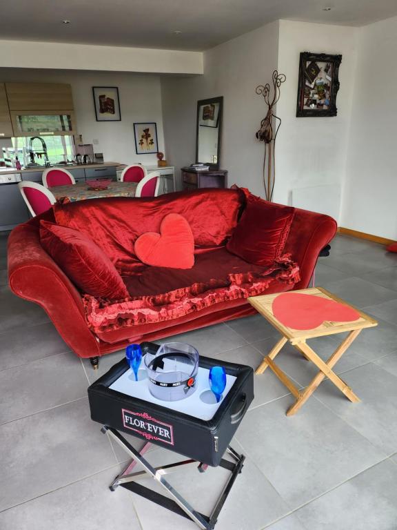 een rode bank met twee harten in een woonkamer bij Flor'Ever en Champagne in Fleury-la-Rivière