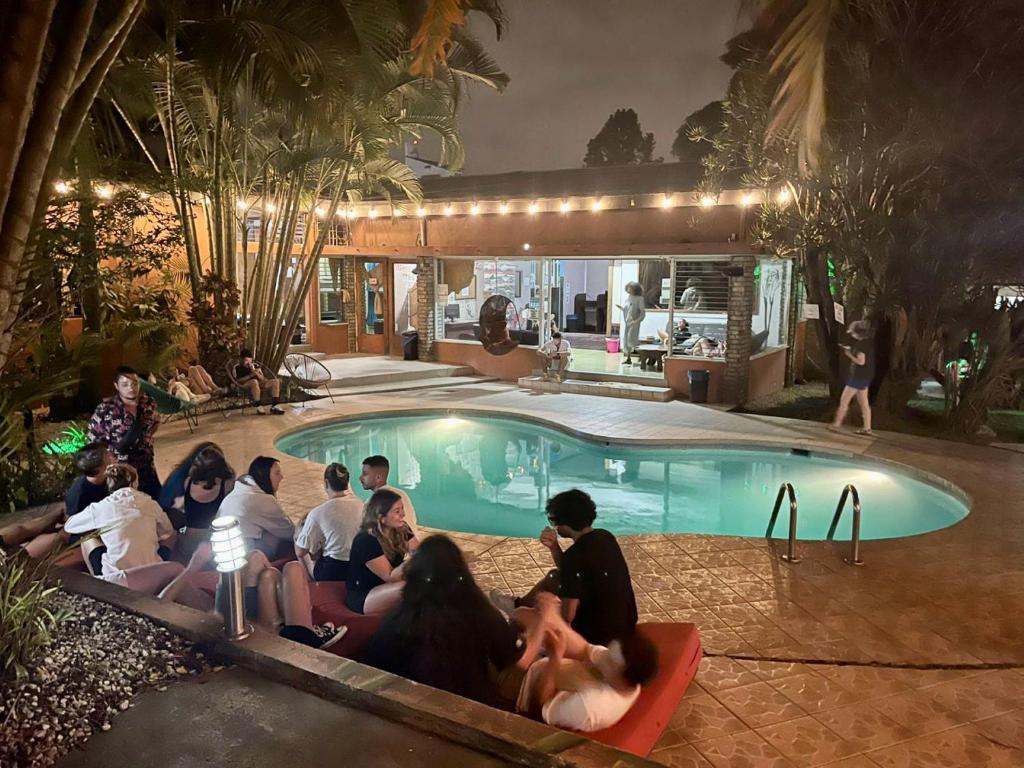 a group of people sitting around a pool at night at Costa Rica Backpackers in San José