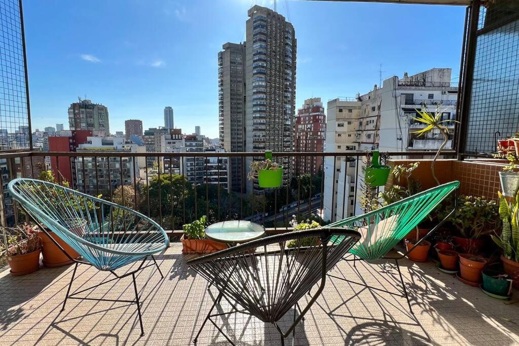 2 sillas y una mesa en un balcón con ciudad en Depto 3 Amb en Palermo Piso Alto en Buenos Aires
