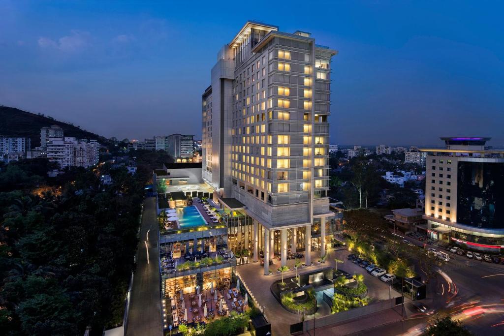 a tall building with lights on in a city at JW Marriott Pune in Pune