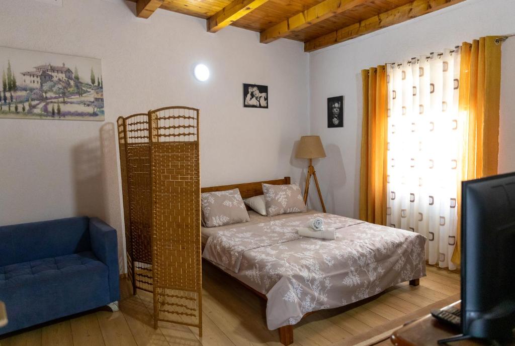 a bedroom with a bed and a blue chair at Apartmani -studio-Sofi in Ulcinj