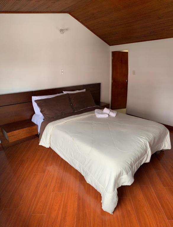 - une chambre avec un grand lit blanc et du parquet dans l'établissement CASA BLANCA, à Sogamoso