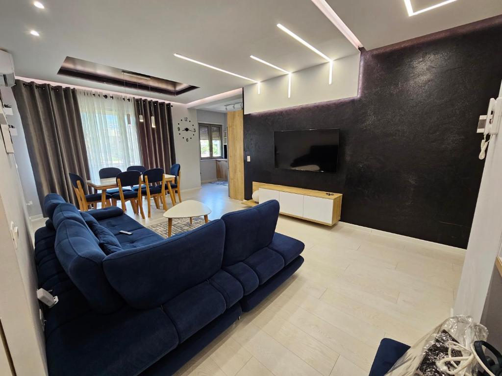a living room with a blue couch and a dining room at Tower Bridge Apartment in Tirana