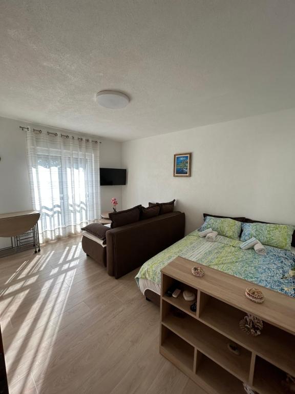 a bedroom with a bed and a couch at Studio Sunrise in Neum