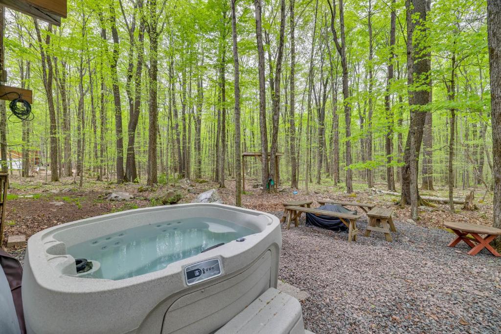 a hot tub in the woods with a picnic table at Hot Tub and Resort Amenities Pocono Lake Retreat! in Pocono Lake