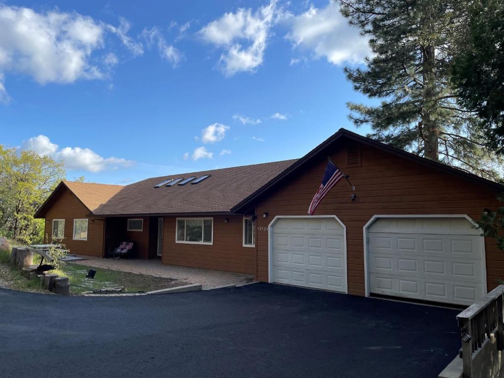 a house with two garage doors and an american flag at Hidden Views B Duplex in Twain Harte