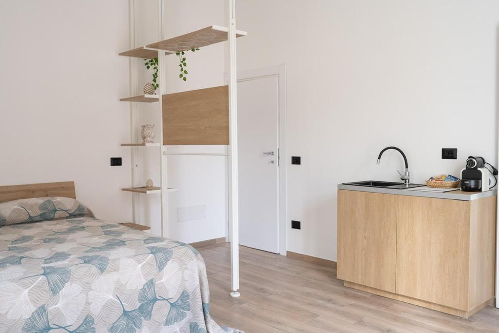 1 dormitorio con 1 cama y cocina con fregadero en B&B Giulia, en Grammichele