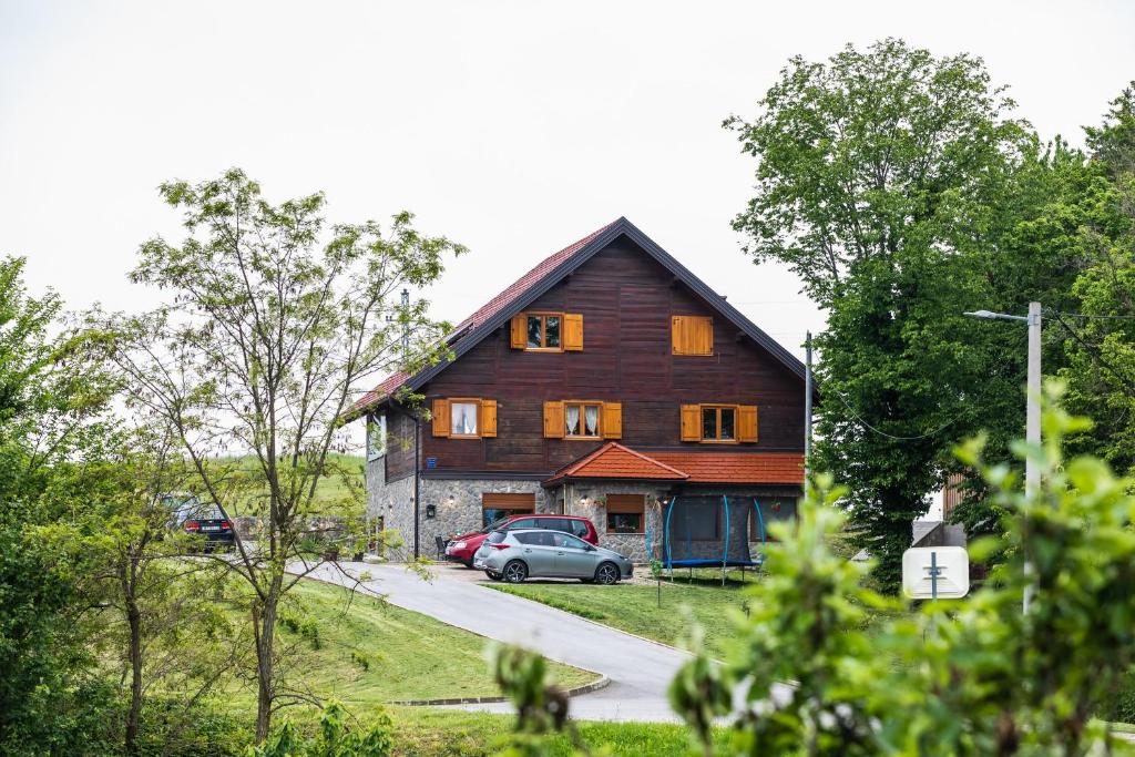 a large wooden barn with a car parked in front of it at Apartment Stone and Wood in Cetingrad
