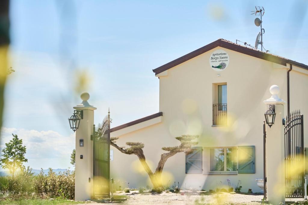 dom z drzewem przed nim w obiekcie Agriturismo Borgonuovo w Rimini