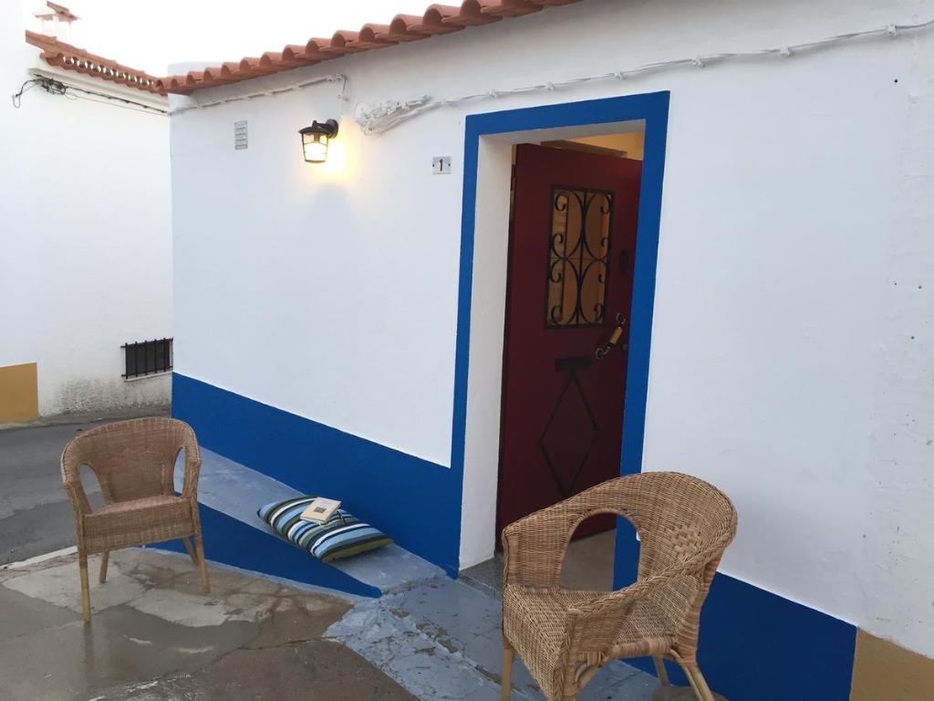 a door and two chairs in front of a house at Recanto do Alqueva in Monsaraz