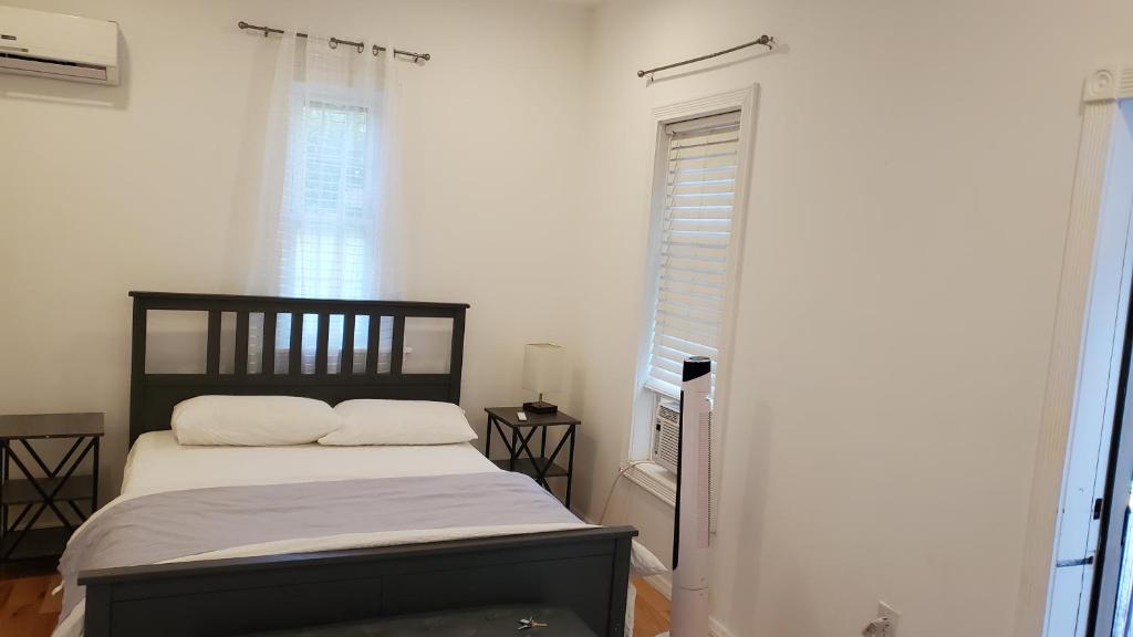 een slaapkamer met een bed en een raam bij Gorgeous Victorian House!! Entire suite in SAM's home in Brooklyn