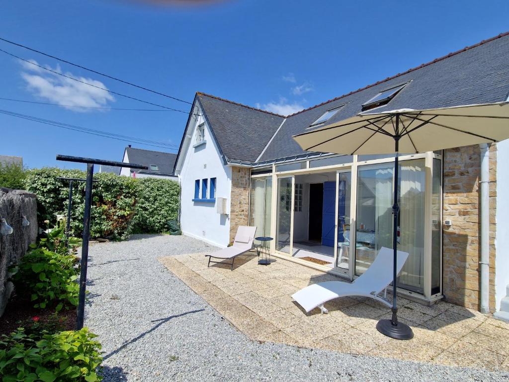 un patio avec deux chaises et un parasol dans l'établissement Maison de vacances 2 personnes à Quiberon, à Quiberon