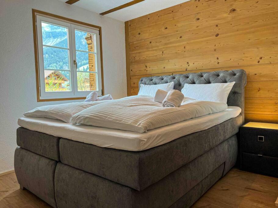a large bed in a room with a window at Alpine Chalet in Kandersteg