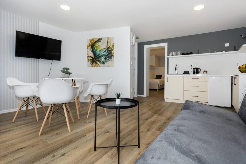 萨拉热窝Royal Grey Apartment的客厅里有一张桌子和一个厨房