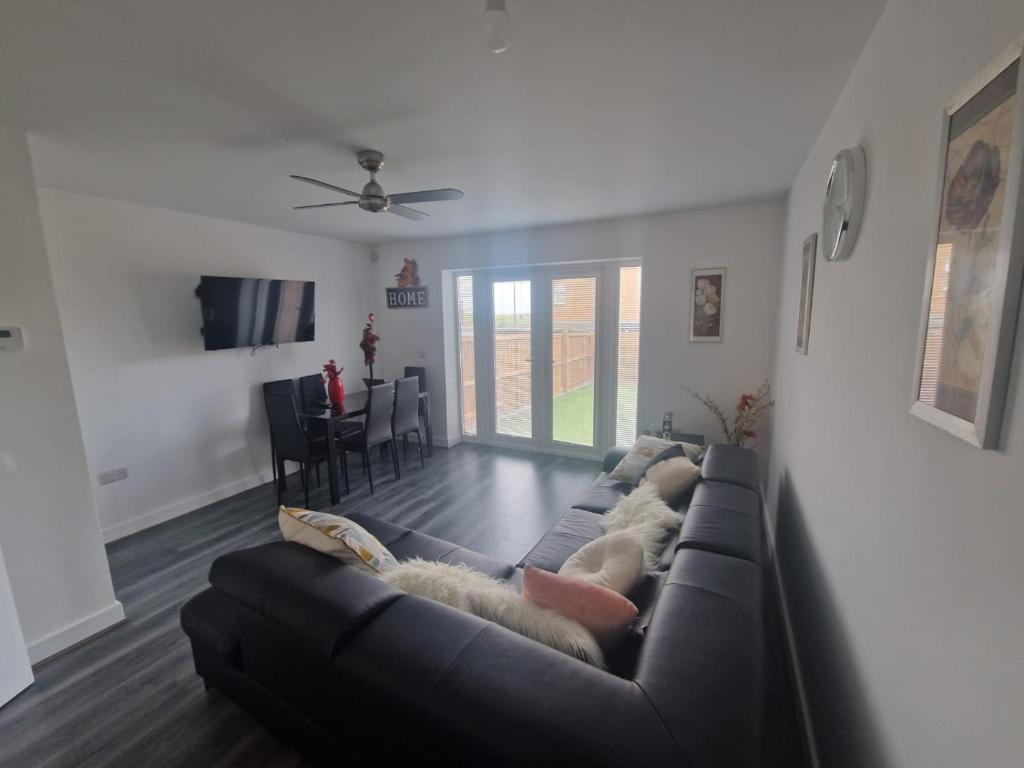 a living room with a black couch and a table at Enjoyable Home in Sunderland