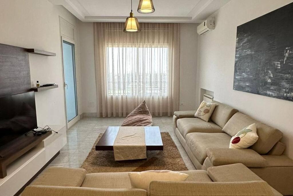 ein Wohnzimmer mit einem Sofa und einem Couchtisch in der Unterkunft un très beau studio luxueux in Ariana