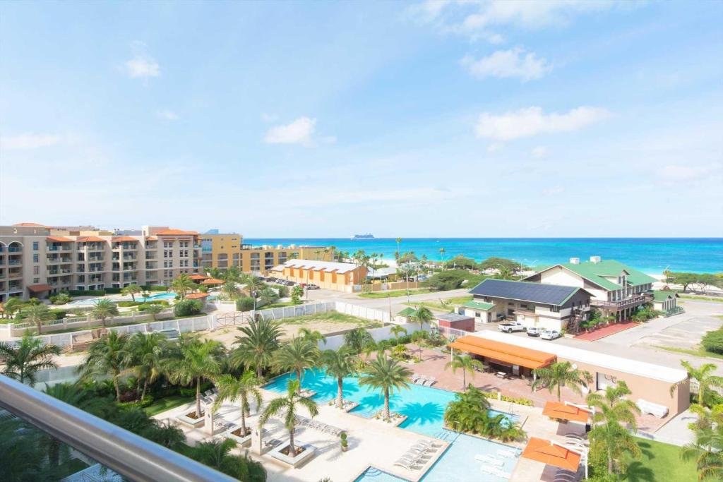 een uitzicht op een resort met een zwembad en de oceaan bij Coastal View Two-bedroom condo in Palm-Eagle Beach