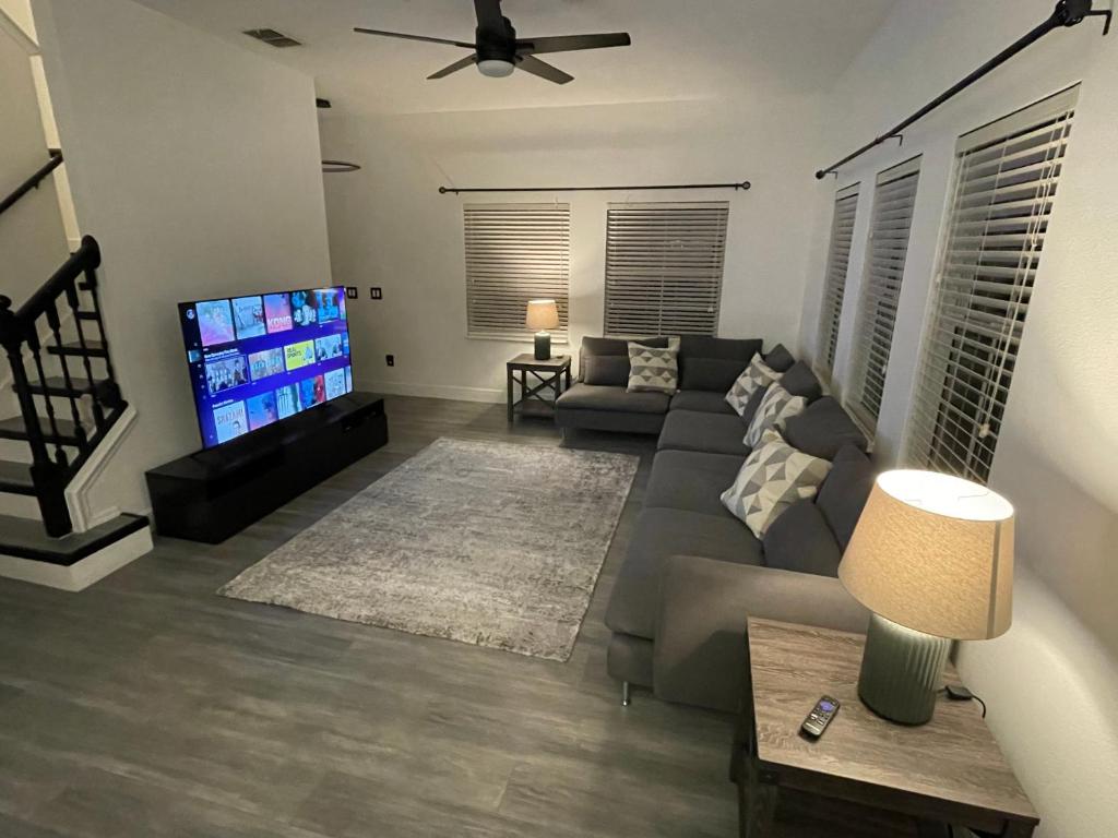 a living room with a couch and a flat screen tv at BellaVida Orlando in Kissimmee