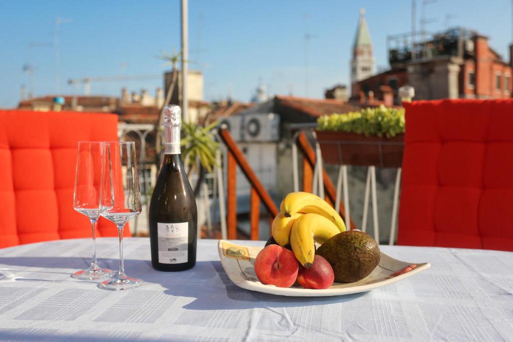 un piatto di frutta su un tavolo con una bottiglia di vino di Cà del paradiso a Venezia