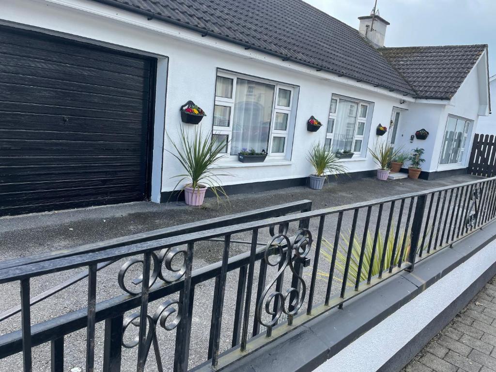 una casa con una puerta de garaje negra y macetas en The Bungalow Castlepollard en Westmeath