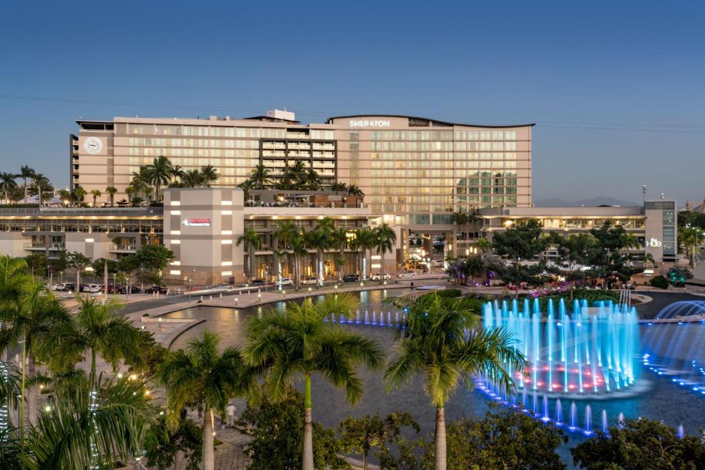 a large building with palm trees and a fountain at Sheraton Puerto Rico Resort & Casino in San Juan