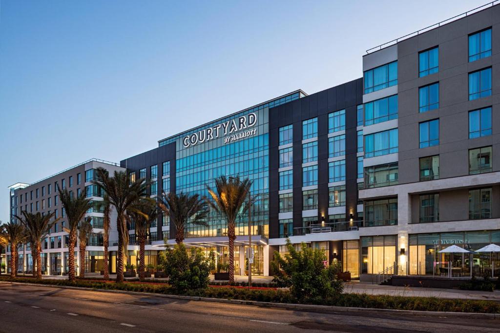 un immeuble de bureaux avec des palmiers devant lui dans l'établissement Courtyard by Marriott Los Angeles Monterey Park, à Monterey Park