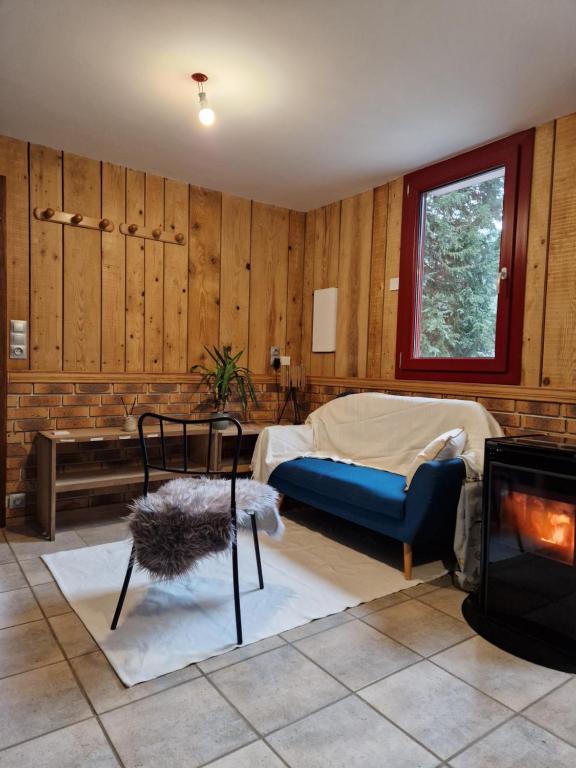 ein Wohnzimmer mit einem Bett und einem Kamin in der Unterkunft Chalet de la forêt 1 à 6 pers in Saint-Sauveur