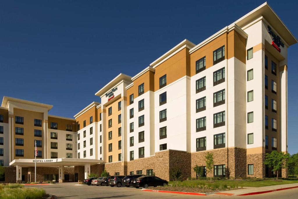een groot gebouw met auto's geparkeerd op een parkeerplaats bij TownePlace Suites by Marriott Dallas DFW Airport North/Grapevine in Grapevine