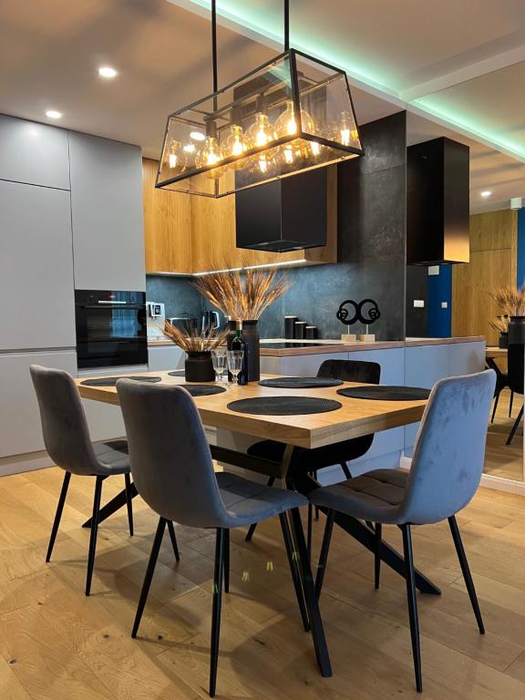 - une cuisine avec une table et des chaises en bois dans l'établissement Family & Business Elegant Apartments, Kadzielnia, WDK, Stadion Korona -1 Bedroom, Terrace, Garage, NEW!, à Kielce