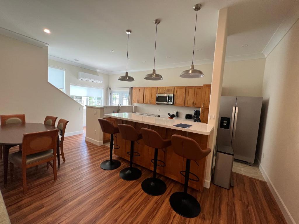 a kitchen with a counter and a table and a refrigerator at Cozy Custom Vacation Home in Kaneohe
