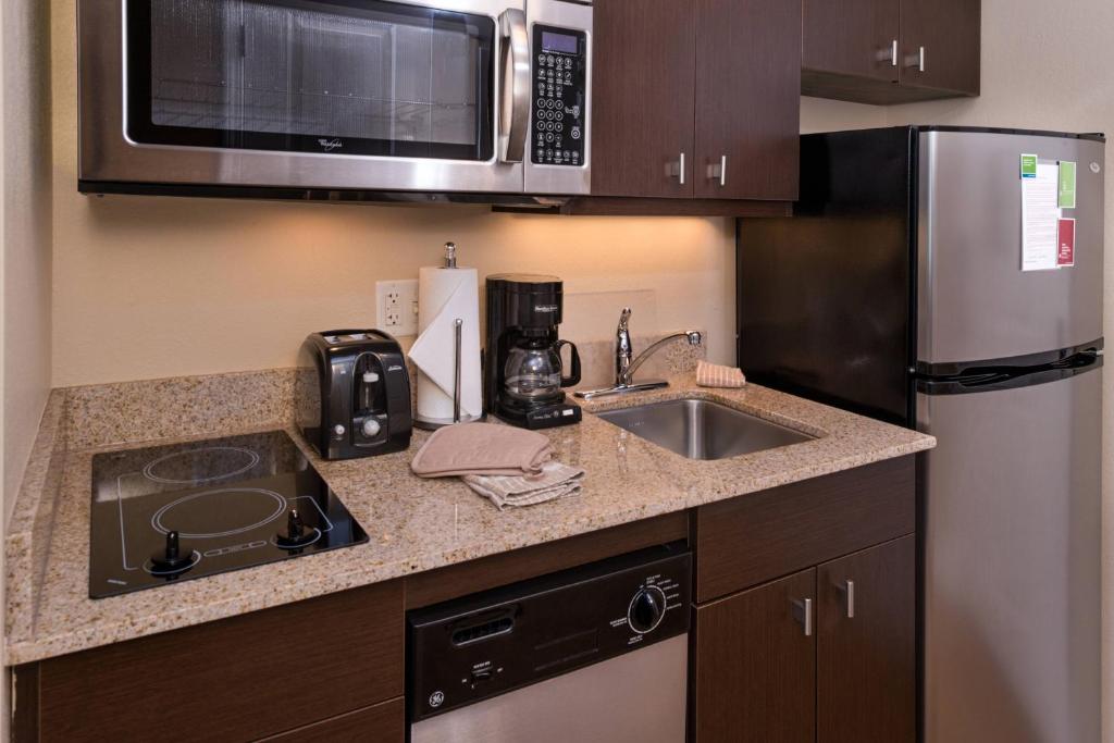 a kitchen with a sink and a microwave at TownePlace Suites Huntington in Huntington