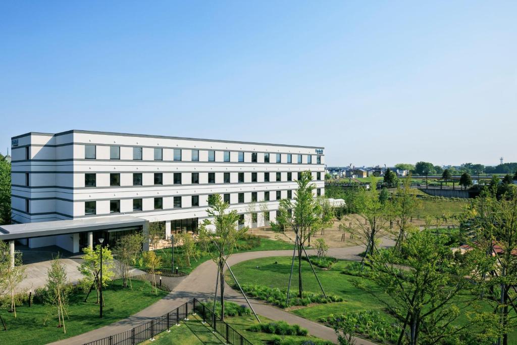 an office building with a garden in front of it at Fairfield by Marriott Hokkaido Eniwa in Eniwa