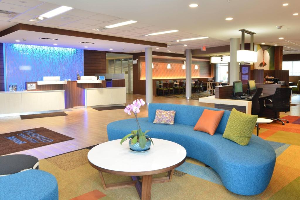 a living room with a blue couch and a table at Fairfield Inn & Suites by Marriott Eau Claire/Chippewa Falls in Eau Claire