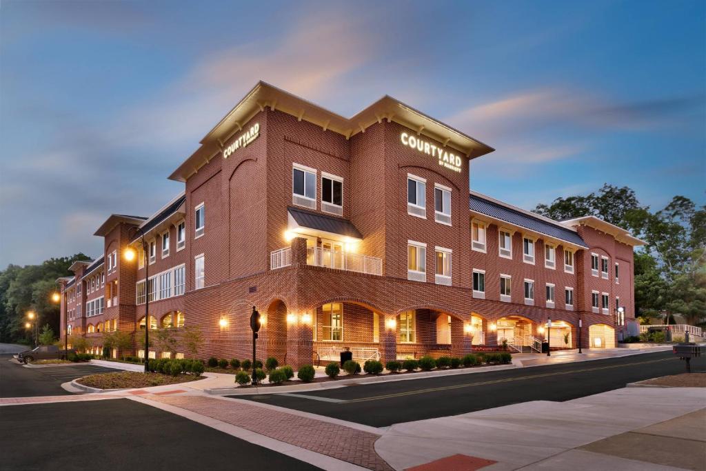 a large brick building on a street at night at Courtyard by Marriott Atlanta Duluth Downtown in Duluth