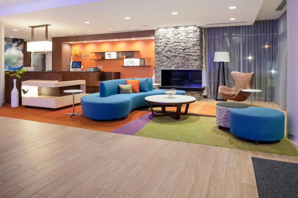 Fairfield Inn & Suites by Marriott Augusta Washington Rd./I-20 في أوغوستا: غرفة معيشة مع أريكة زرقاء وطاولة