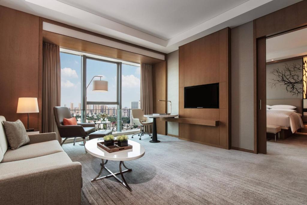 um quarto de hotel com uma cama king-size e uma sala de estar em Courtyard by Marriott Changsha South em Changsha