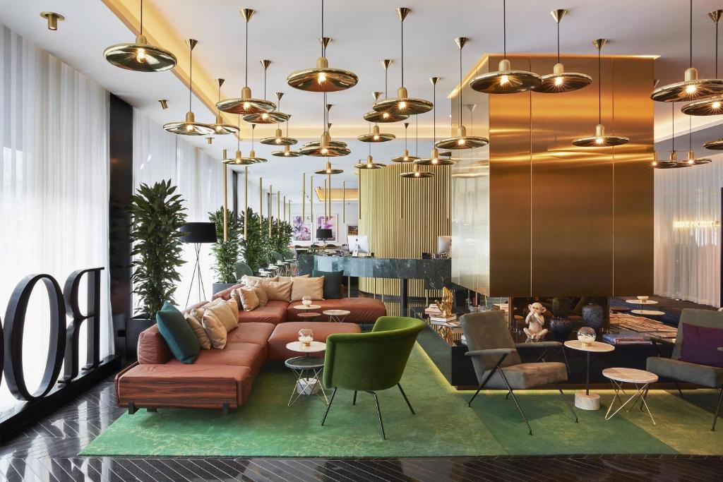 a lobby with a couch and chairs and tables at Roomers Munich, Autograph Collection in Munich