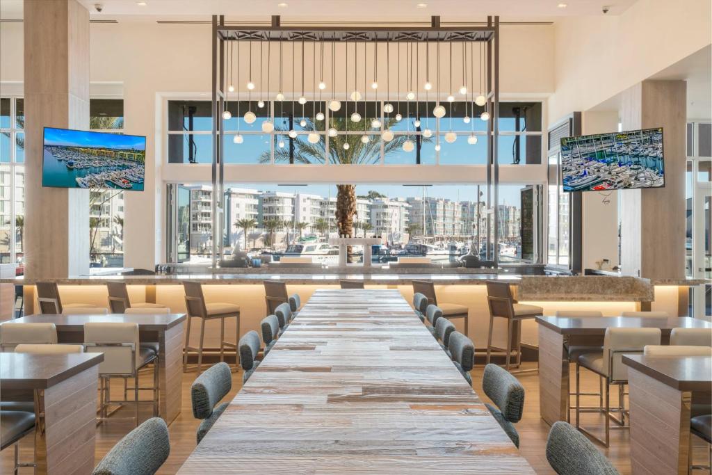 een lange tafel in een restaurant met tafels en stoelen bij Courtyard by Marriott Marina del Rey in Los Angeles