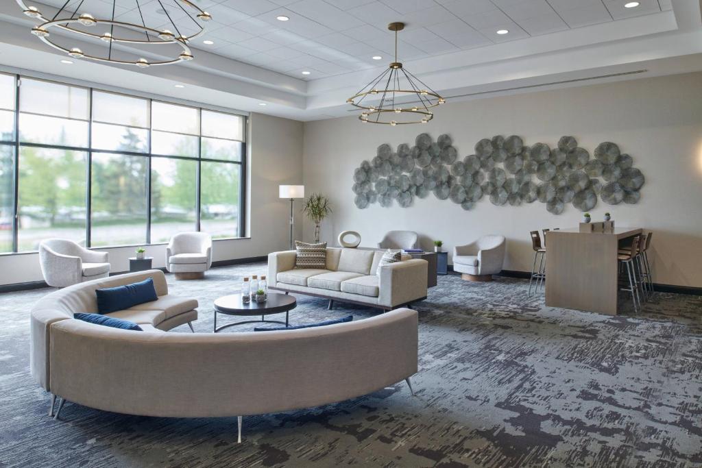 una gran sala de estar con sofás y una mesa. en Delta Hotels by Marriott Detroit Novi, en Farmington Hills