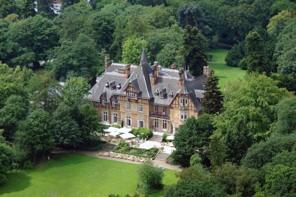 eine Luftansicht eines großen Hauses in den Bäumen in der Unterkunft Villa Rothschild, Autograph Collection in Königstein im Taunus