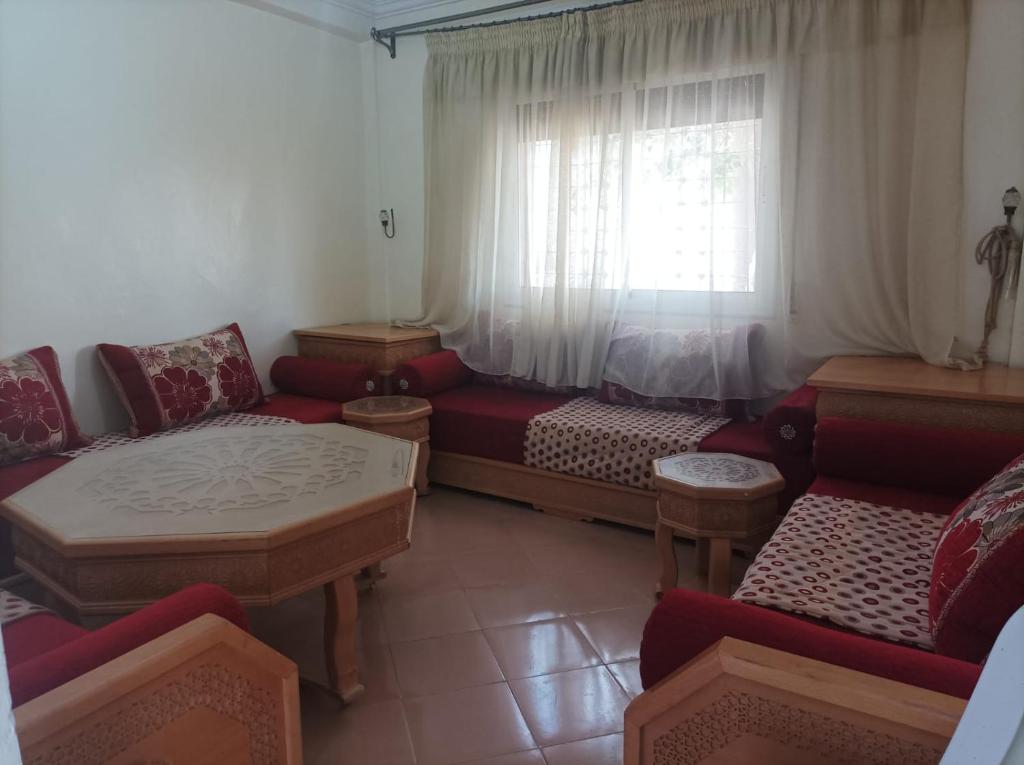 een woonkamer met een bank en een raam bij Jolie Maison pas chère in Oujda