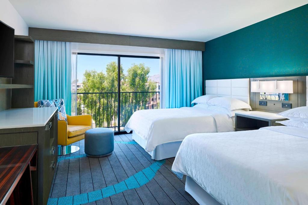 um quarto de hotel com duas camas e uma varanda em Sheraton Tucson Hotel & Suites em Tucson