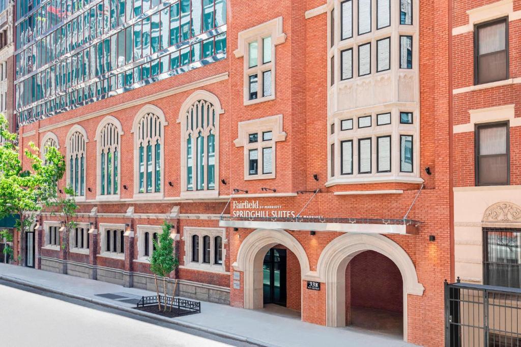 a red brick building with an archway on a street at Fairfield Inn & Suites by Marriott New York Manhattan/Times Square South in New York