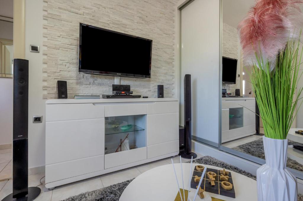 Telewizja i/lub zestaw kina domowego w obiekcie Uniquely designed Villa Ivana with outdoor Jacuzzi nearby the pebble Banje beach at the Island of Solta