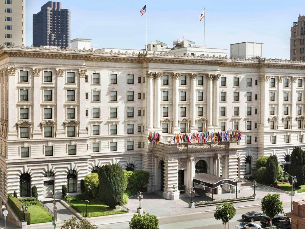 Un edificio bianco con bandiere americane sopra. di Fairmont San Francisco a San Francisco