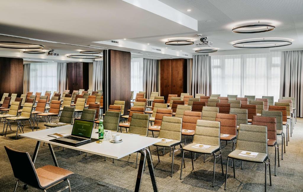 a conference room with tables and chairs and a laptop at Grand Tirolia Kitzbühel - Member of Hommage Luxury Hotels Collection in Kitzbühel