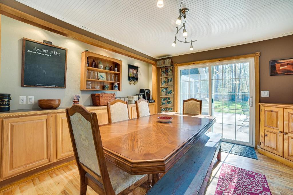 a dining room with a wooden table and a chalkboard at Roscommon Vacation Rental about 1 Mi to Higgins Lake! in Roscommon